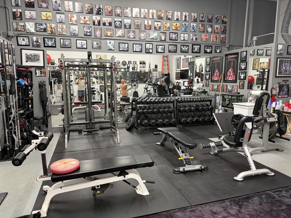 The Parabody rack, dumbbells and the client photo wall